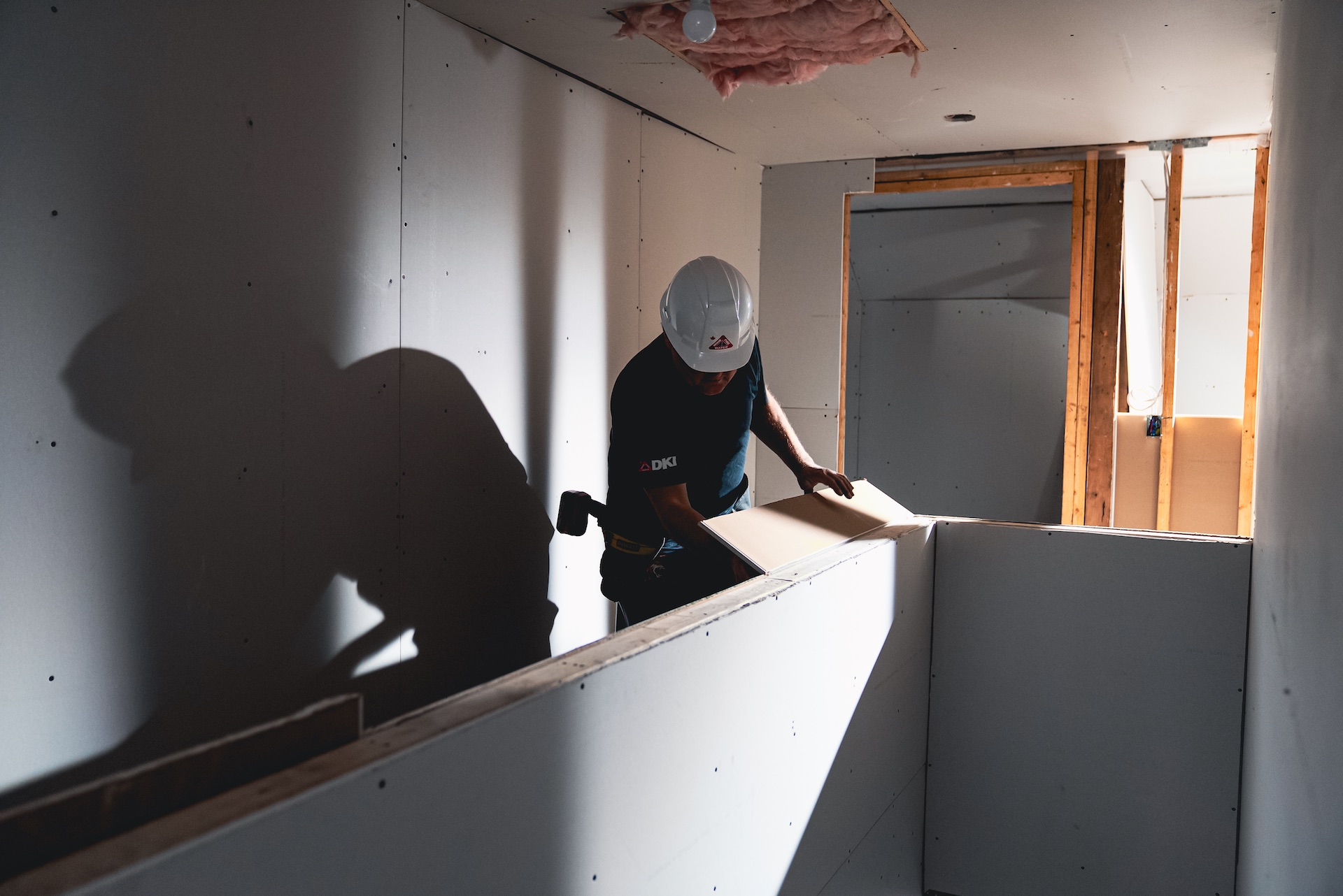DKI technician working on damaged ceiling and wall framing