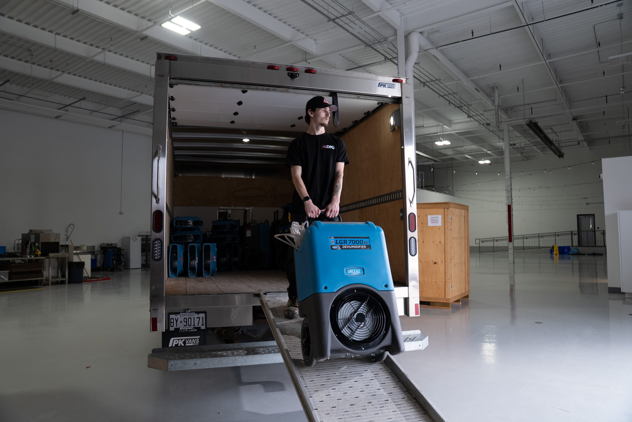 DKI technician loading a dehumidifier into a restoration truck